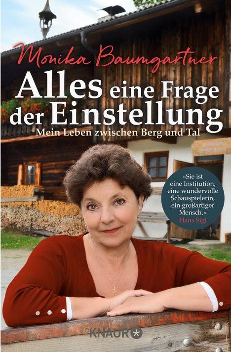 „Monika Baumgartner – Alles eine Frage der Einstellung. Mein Leben zwischen Berg und Tal.“ Frau lehnt an Holzzaun.