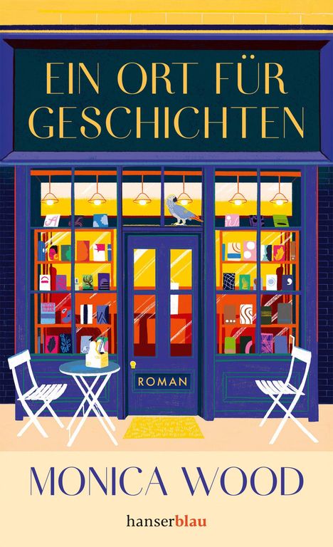 "Ein Ort für Geschichten", "Roman", "Monica Wood", "hanserblau". Bunte Buchhandlung mit Tisch und Stuhl, Papagei auf Tür.