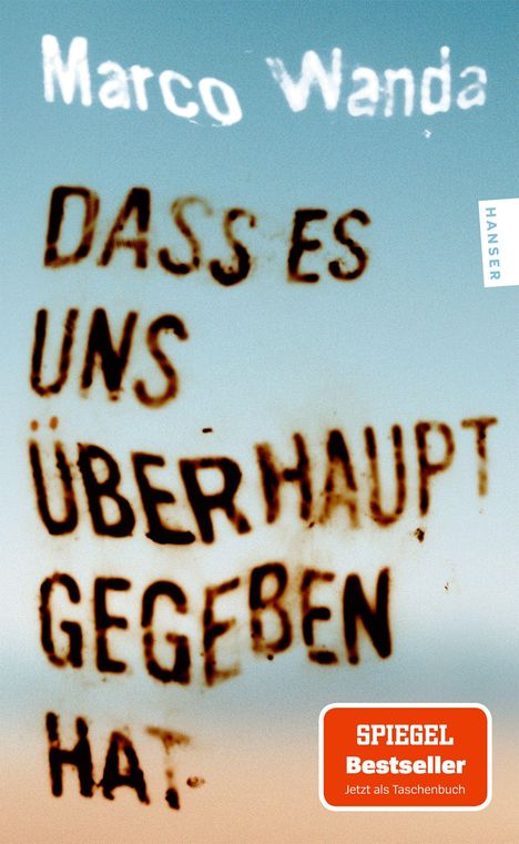 Text: "Marco Wanda", "DASS ES UNS ÜBERHAUPT GEGEBEN HAT", "SPIEGEL Bestseller". Hintergrund unscharf in Blau- und Brauntönen.