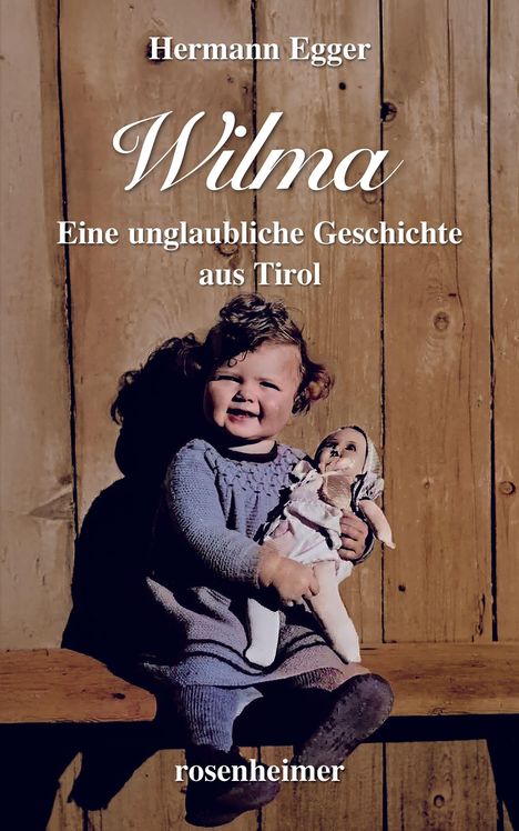 "Hermann Egger, Wilma: Eine unglaubliche Geschichte aus Tirol. rosenheimer." Kleines Kind mit Puppe auf Holzhintergrund.