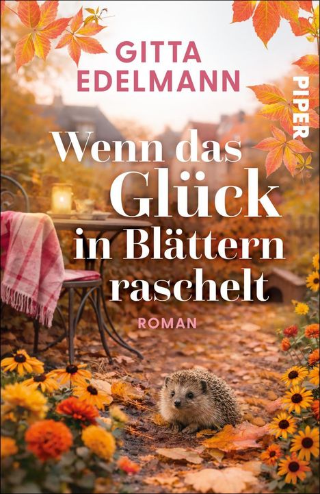 Der Titel lautet "Wenn das Glück in Blättern raschelt". Ein Igel sitzt zwischen Herbstblumen und einem Tisch mit Decke.