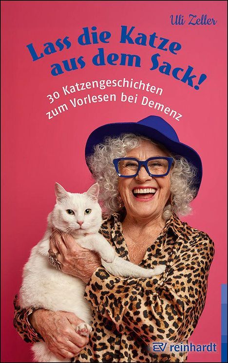 Buchtitel: "Lass die Katze aus dem Sack!" Eine Frau mit weißer Katze, Hut und Brille lächelt.