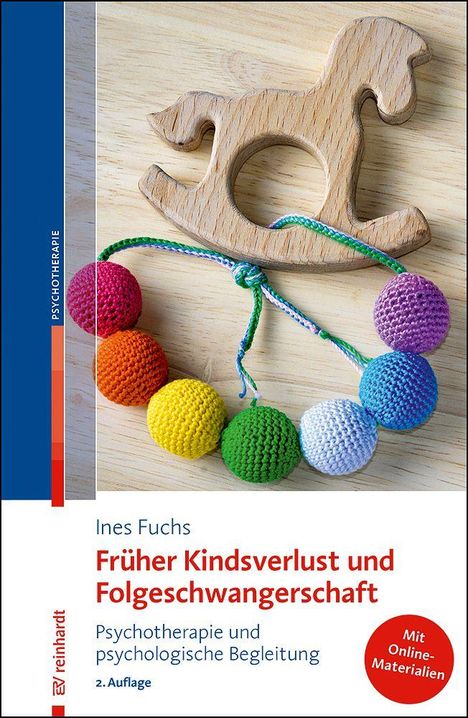 "Früher Kindsverlust und Folgeschwangerschaft" von Ines Fuchs. Holzspielzeug-Pferd und bunte Kugeln auf Holzuntergrund.