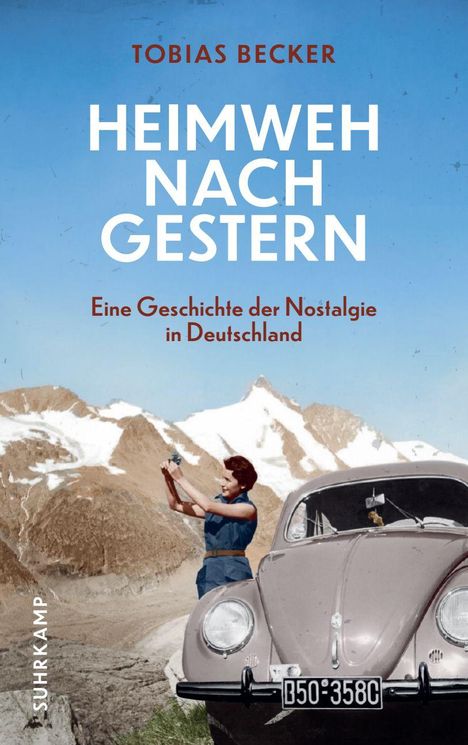 "Heimweh nach Gestern" von Tobias Becker. Frau fotografiert neben einem alten Auto in einer Gebirgslandschaft.