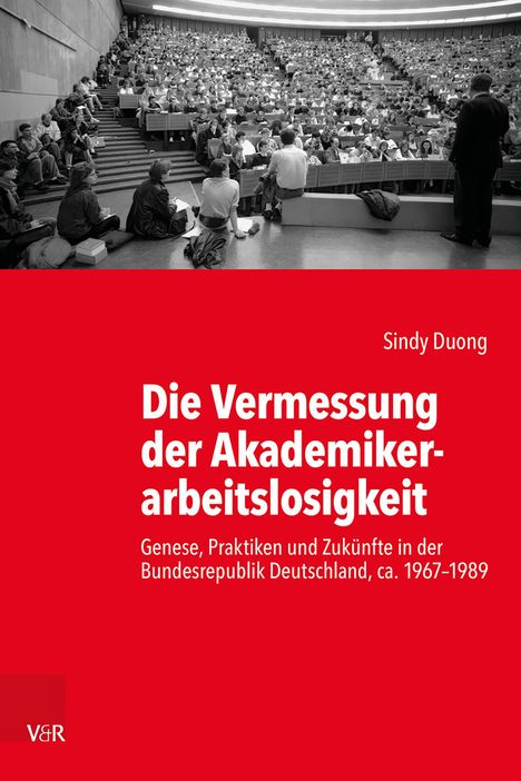 Titel: "Die Vermessung der Akademikerarbeitslosigkeit". Ein überfüllter Hörsaal mit vielen Studierenden.