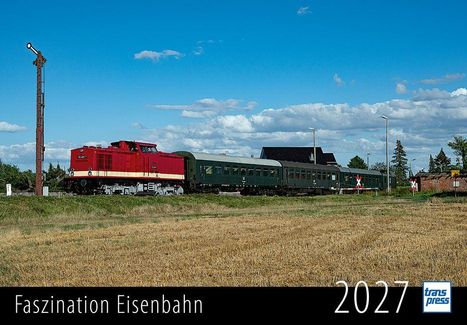 Faszination Eisenbahn 2027. Eine rote Lokomotive zieht grüne Waggons durch ländliche Landschaft, blauer Himmel.