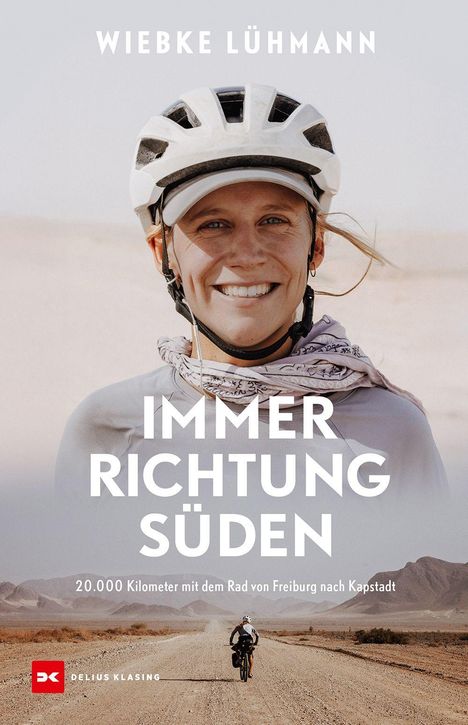 Titel: Immer Richtung Süden; Untertitel: 20.000 Kilometer mit dem Rad; Eine Frau mit Helm lächelt, im Hintergrund Wüste.