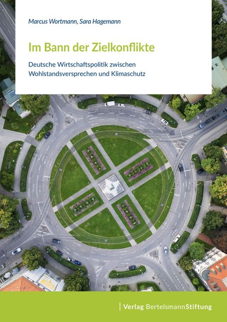 "Im Bann der Zielkonflikte" von Marcus Wortmann und Sara Hagemann. Luftaufnahme eines Kreisverkehrs mit Grünflächen.