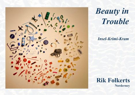 Texte: "Beauty in Trouble", "Insel-Krimi-Kram", "Rik Folkerts", "Norderney". Eine Sammlung bunter Gegenstände in Kreisform.
