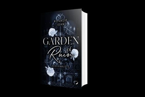 Text: „Garden of Ruin, Seelenblüte, Rosalie John“. Buchcover zeigt ein dunkles, verziertes Tor mit weißen Blumen.