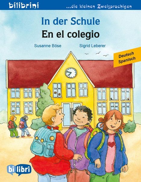 Oben steht "In der Schule / En el colegio". Darunter eine Illustration von drei Kindern vor einer gelben Schule.