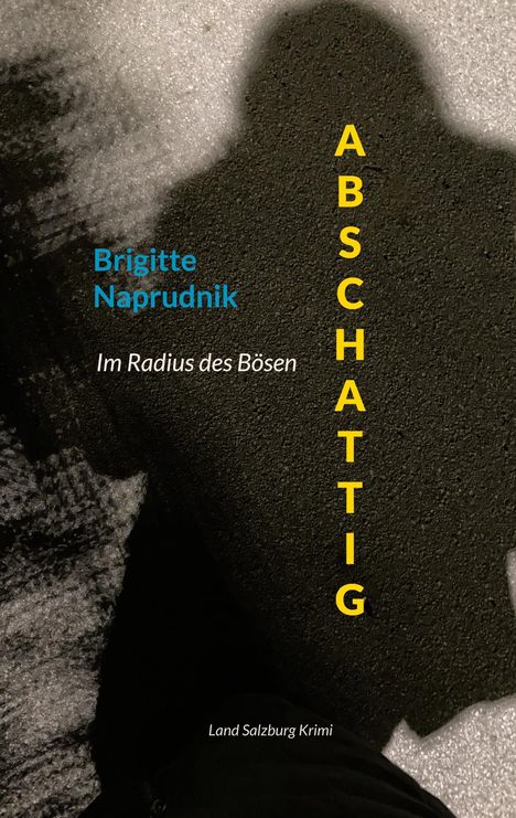 Text: "ABSCHATTIG", "Brigitte Naprudnik", "Im Radius des Bösen", "Land Salzburg Krimi". Schatten eines Menschen auf Asphalt.