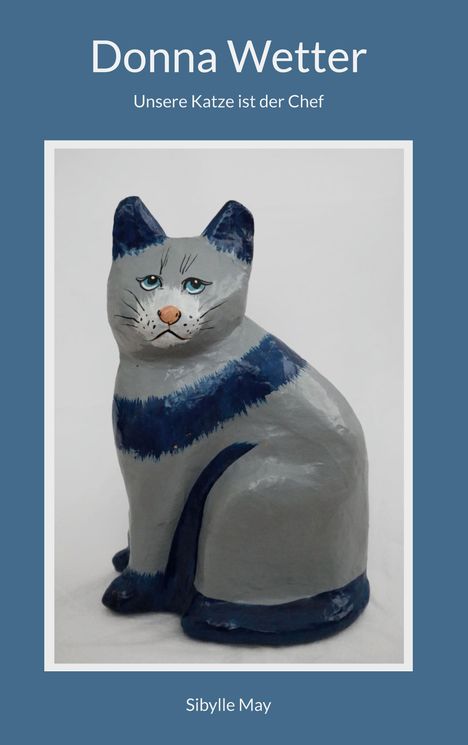 „Donna Wetter. Unsere Katze ist der Chef.“ Darunter eine bemalte Katzenskulptur in Grau und Blau. "Sibylle May".