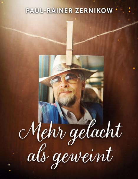 PAUL-RAINER ZERNIKOW, Mehr gelacht als geweint. Ein Foto an einer Schnur zeigt einen Mann mit Hut und Sonnenbrille.