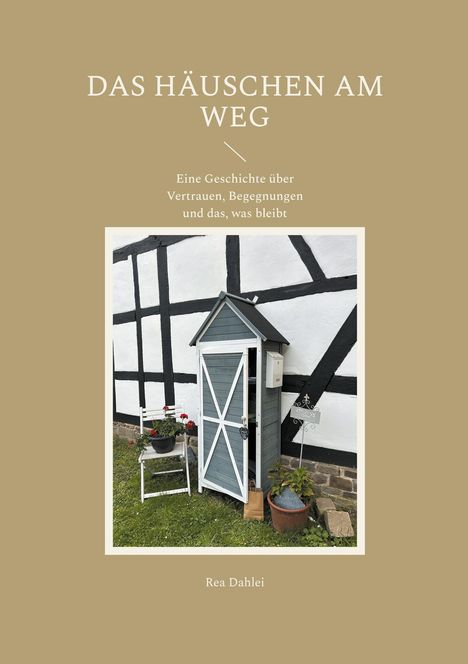 „Das Häuschen am Weg. Eine Geschichte über Vertrauen, Begegnungen und das, was bleibt.“ Fachwerkhaus mit kleinem Häuschen.