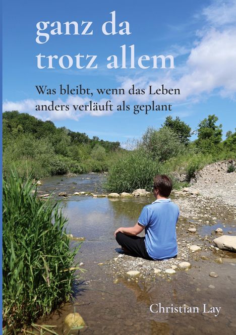 Text: "ganz da trotz allem. Was bleibt, wenn das Leben anders verläuft als geplant. Christian Lay." Ein Mann sitzt am Fluss.