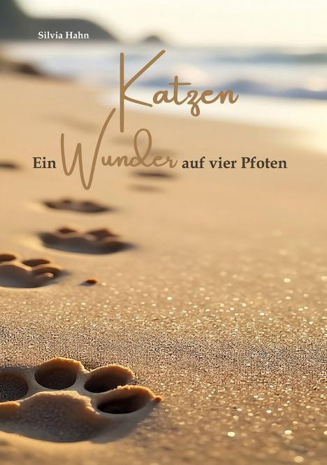 Texte: "Silvia Hahn", "Katzen", "Ein Wunder auf vier Pfoten". Sandstrand mit Pfotenabdrücken, Meereswellen im Hintergrund.