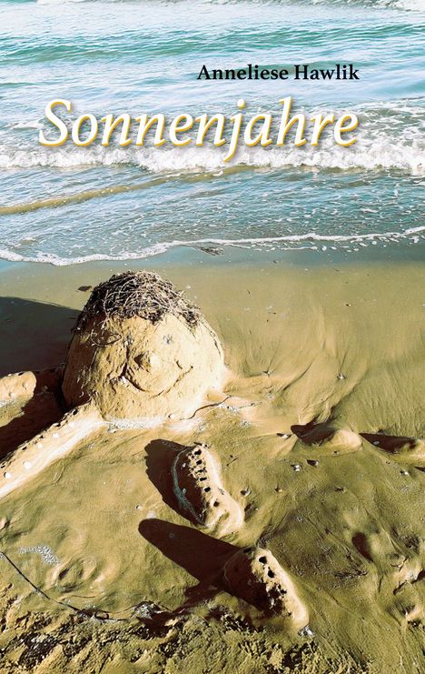„Anneliese Hawlik“, „Sonnenjahre“. Sandfigur mit Gesicht am Strand, Meer im Hintergrund.