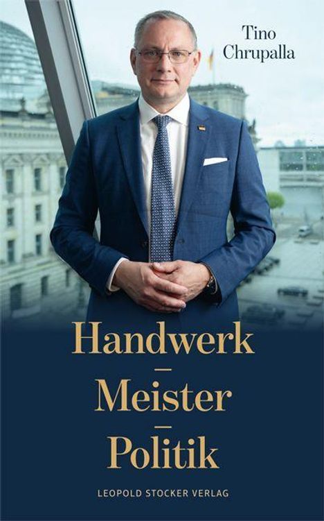 Text: "Handwerk Meister Politik" und "Tino Chrupalla". Ein Mann in Anzug steht vor einem Fenster mit Blick auf Gebäude.