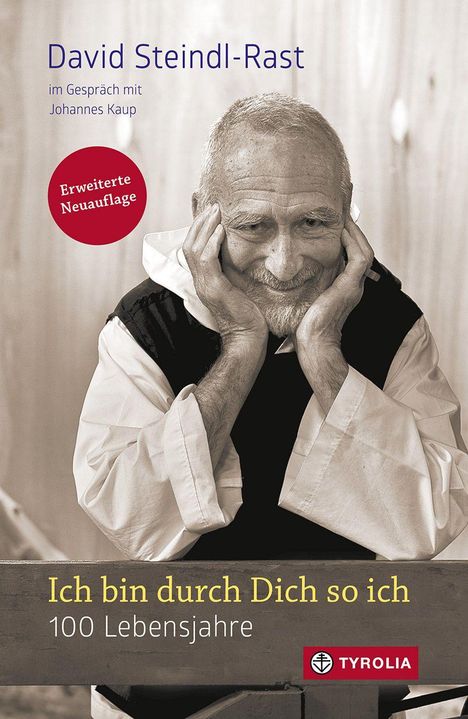 Text: "David Steindl-Rast", "Ich bin durch Dich so ich", "100 Lebensjahre". Ein lächelnder Mann stützt sein Gesicht mit den Händen.