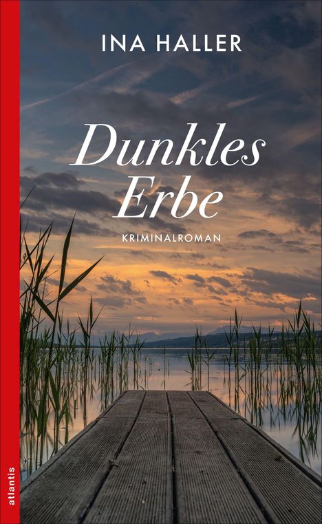 "Dunkles Erbe. Kriminalroman. Ina Haller." Ein Steg führt zu einem See bei Sonnenuntergang, umgeben von Schilf.