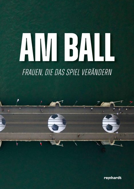 „AM BALL: FRAUEN, DIE DAS SPIEL VERÄNDERN“ in Großbuchstaben, darunter eine Luftaufnahme einer Brücke mit Fußbällen.