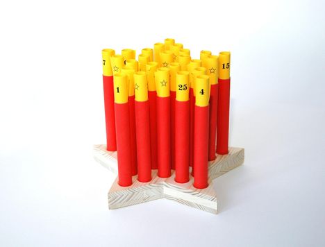Nummern: "1", "4", "7", "15", "25". Gelbe, rote Rollen auf Holzbasis in Sternform, wie Kerzen platziert.