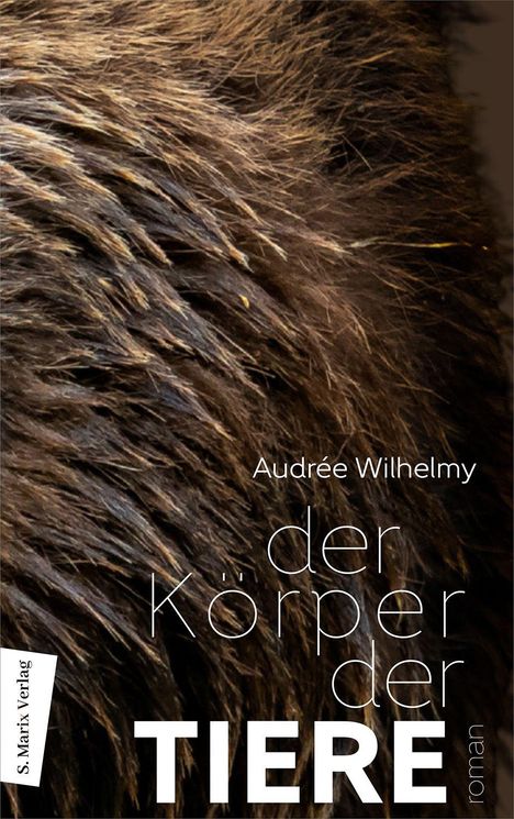 Text: "Audrée Wilhelmy, der Körper der TIERE, roman, S. Marix Verlag." Hintergrund: Nahaufnahme von braunem Fell.