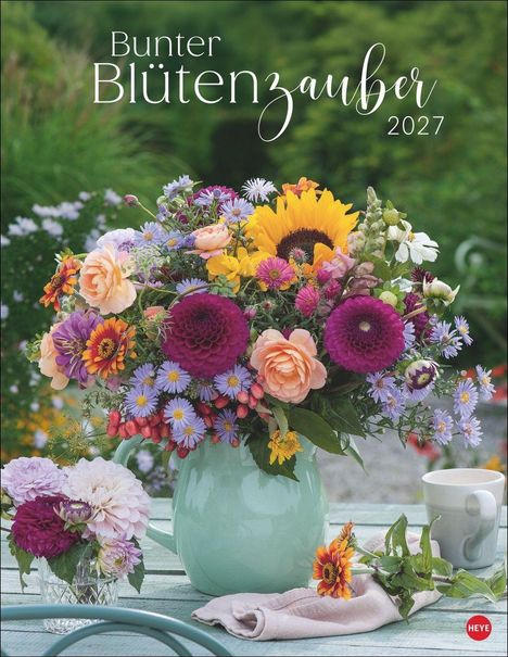 "Bunter Blütenzauber 2027". Ein großer, bunter Blumenstrauß in einer grün-blauen Vase auf einem Tisch.