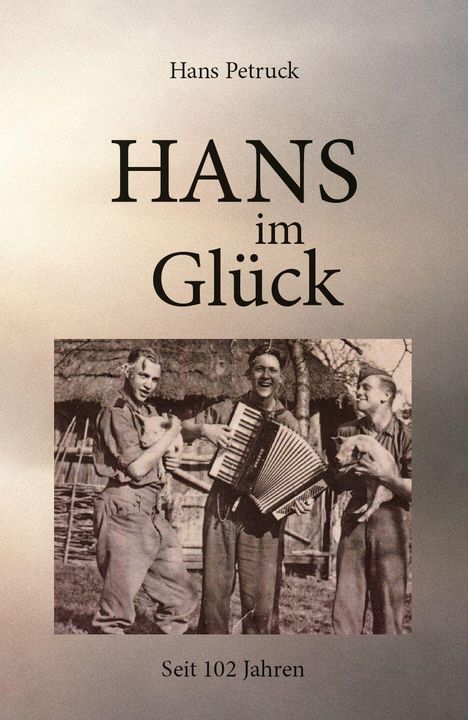 „Hans Petruck“, „HANS im Glück“, „Seit 102 Jahren“. Sepia-Foto: Drei lachende Männer, einer mit Akkordeon, zwei halten Tiere.
