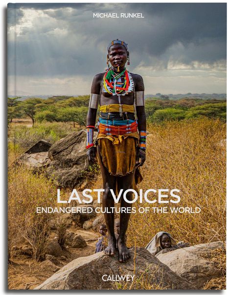 LAST VOICES: ENDANGERED CULTURES OF THE WORLD. CALMEY. Person in traditioneller Kleidung steht in einer Savannenlandschaft.