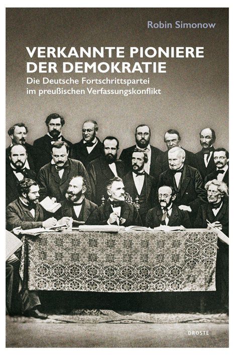 "Verkannte Pioniere der Demokratie" von Robin Simonow. Eine historische Aufnahme von Männern im Anzug um einen Tisch.