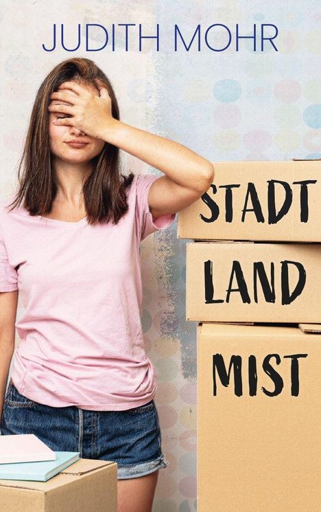 Text: "JUDITH MOHR", "STADT LAND MIST". Frau in rosa Shirt, hält Hand vor das Gesicht, steht neben Kartons.