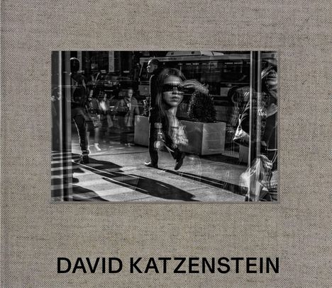 DAVID KATZENSTEIN. Schwarz-weißes Foto von Menschen und Spiegelungen auf einer belebten Straße.