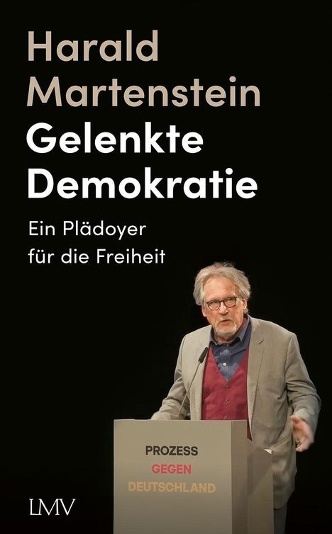 "Harald Martenstein - Gelenkte Demokratie. Ein Plädoyer für die Freiheit." Ein Mann steht hinter einem Rednerpult.