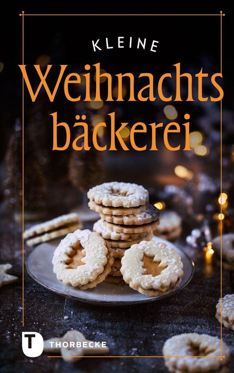 „Kleine Weihnachtsbäckerei.“ Darunter stapeln sich mit Puderzucker bestreute Kekse auf einem Teller. Begeistert gestaltete Atmosphäre.