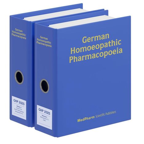 Zwei blaue Ordner, ein großer mit „German Homoeopathic Pharmacopoeia“ und ein kleinerer mit „GHP 2025 Volume 2“.