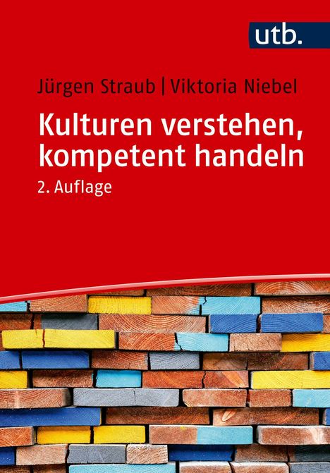 Roter Hintergrund mit Buchtext. Titel: "Kulturen verstehen, kompetent handeln", darüber zwei Autoren. Unten bunte Holzstapel.