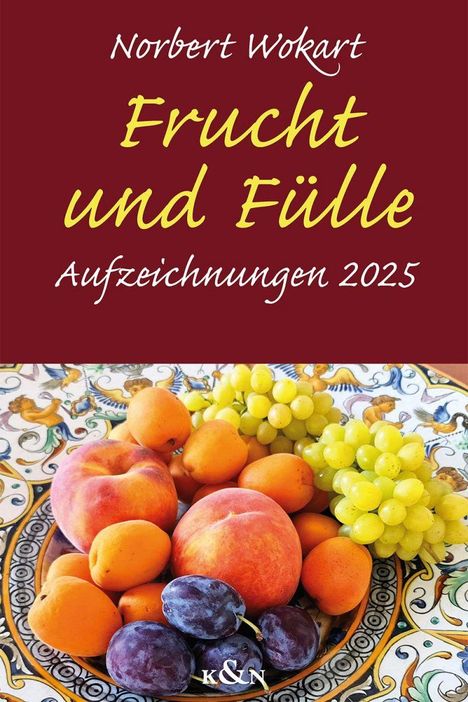„Frucht und Fülle: Aufzeichnungen 2025“. Ein dekorativer Teller mit Pfirsichen, Aprikosen, Trauben und Pflaumen.