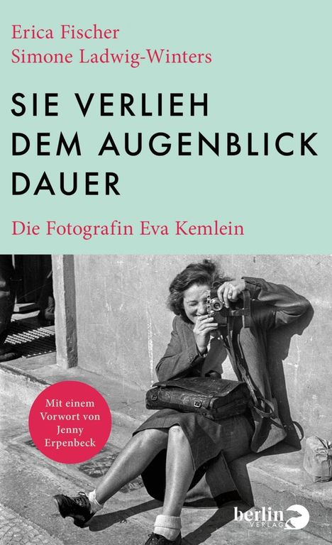 Buchtitel: „Sie verlieh dem Augenblick Dauer“. Bild einer Frau, die draußen mit einer Kamera fotografiert.