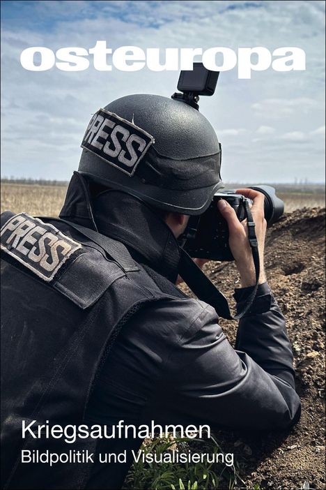 "Kriegaufnahmen. Bildpolitik und Visualisierung." Ein Fotograf mit Helm und Presseweste kniet in einem Graben mit Kamera.