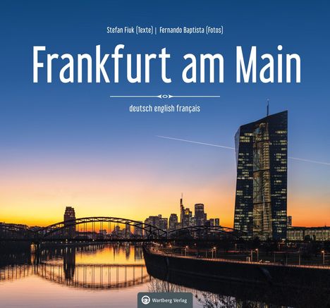 „Frankfurt am Main“ in großer, weißer Schrift; städtische Skyline bei Sonnenuntergang mit einem Fluss im Vordergrund.