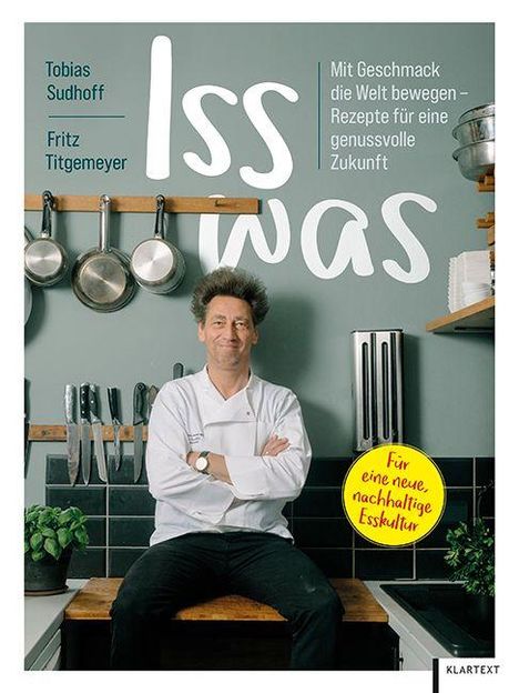 Buchcover: "Iss was". Autoren: Tobias Sudhoff, Fritz Tietmeyer. „Mit Geschmack die Welt bewegen“. Koch vor Küche mit Topfdeckeln.
