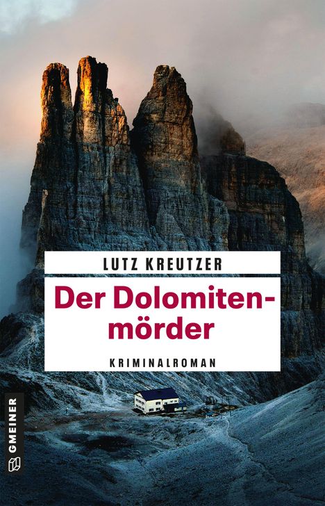 Text: "Lutz Kreutzer, Der Dolomitenmörder, Kriminalroman." Ein einsames Gebäude vor beeindruckenden Berggipfeln.