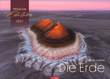 Texte: "PREMIUM Edition 2027", "DANIEL KORDAN Die Erde". Eine farbenfrohe, geologische Formation in der Wüste, rot beleuchtet.