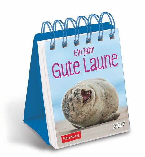 Tischkalender „Ein Jahr Gute Laune“ 2027 mit einem lachenden Seehund auf sandigem Hintergrund, blaues Spiralbindungsdesign.