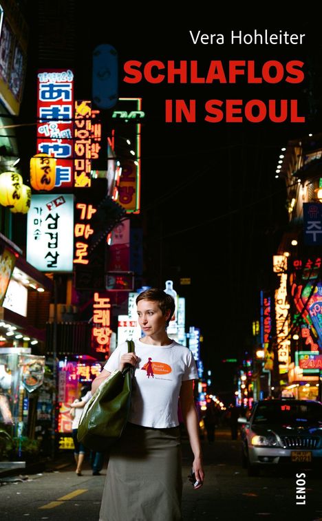 „SCHLAFLOS IN SEOUL“ von Vera Hohleiter. Helle Neonlichter in einer belebten nächtlichen Straße.