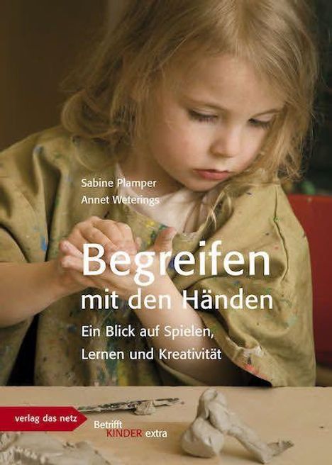 Titel: "Begreifen mit den Händen". Ein Kind formt konzentriert mit Ton.