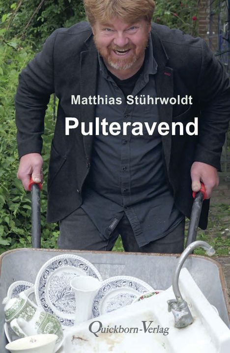 „Matthias Stührwoldt – Pulteravend“, ein lächelnder Mann schiebt eine mit Geschirr gefüllte Schubkarre.