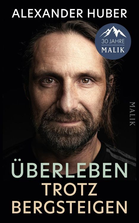 Text: "ALEXANDER HUBER", "ÜBERLEBEN TROTZ BERGSTEIGEN", "MALIK". Nahaufnahme eines Mannes mit Bart vor schwarzem Hintergrund.